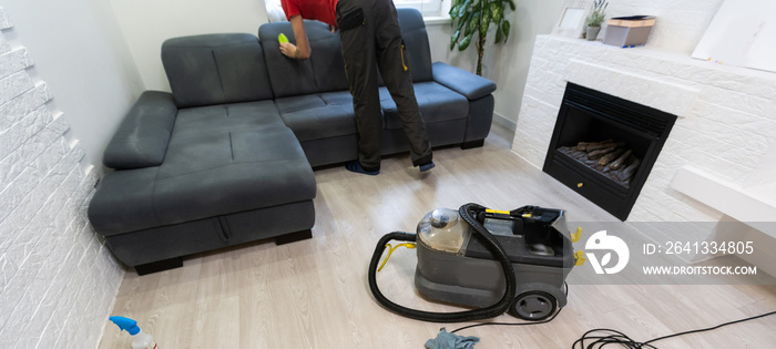 Man dry cleaners employee cleaning sofa with professionally extraction method