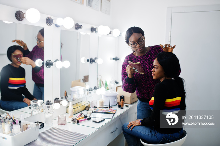 化妆师在美容院化妆的非裔美国妇女。
