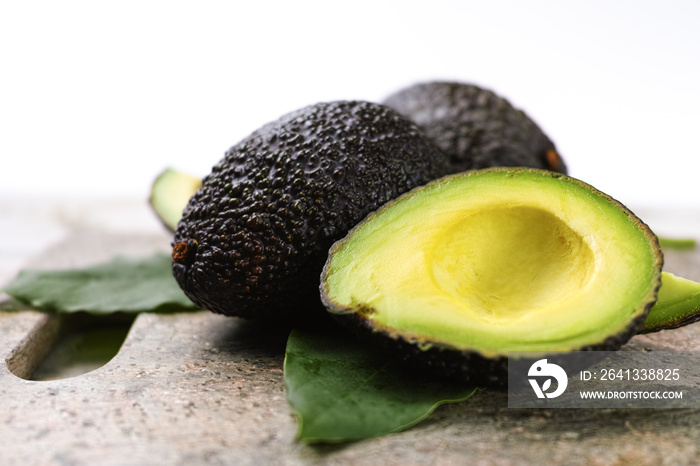 Green ripe avocado with leaves close up