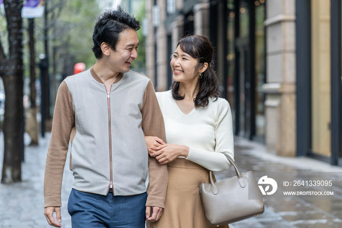 年轻的亚洲情侣走在购物街上
