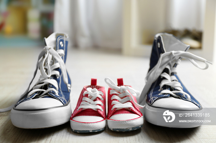 Big and small shoes on wooden floor