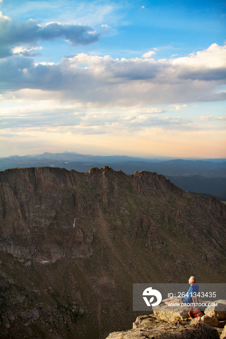 Mature man on cliff overlooking mountain range