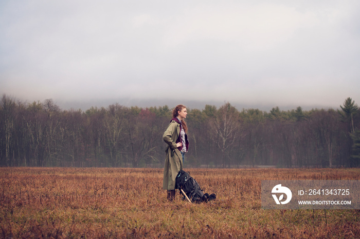 Young female hiker standing in meadow