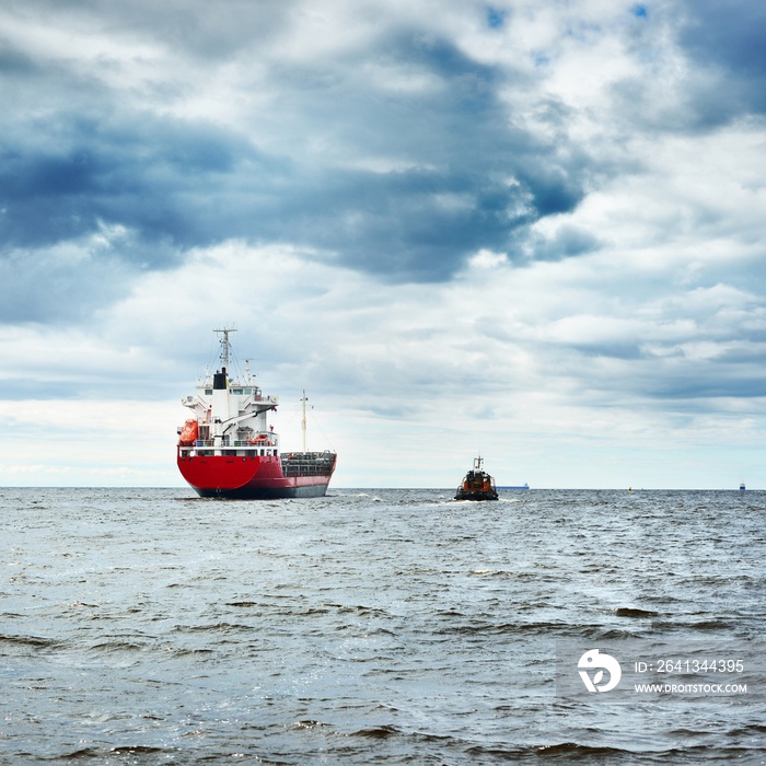 General cargo ship next to a tugboat in a open sea. Klaipeda, Lithuania