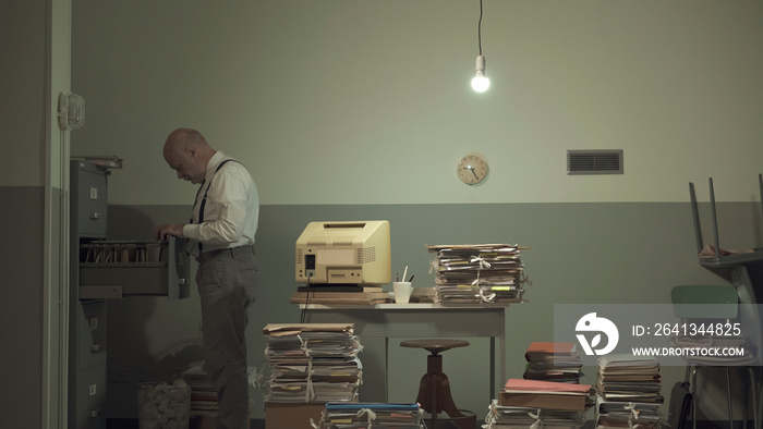 Businessman searching for files in a messy office