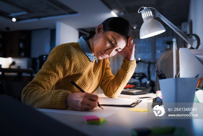 Young freelance entrepreneur woman working late at home