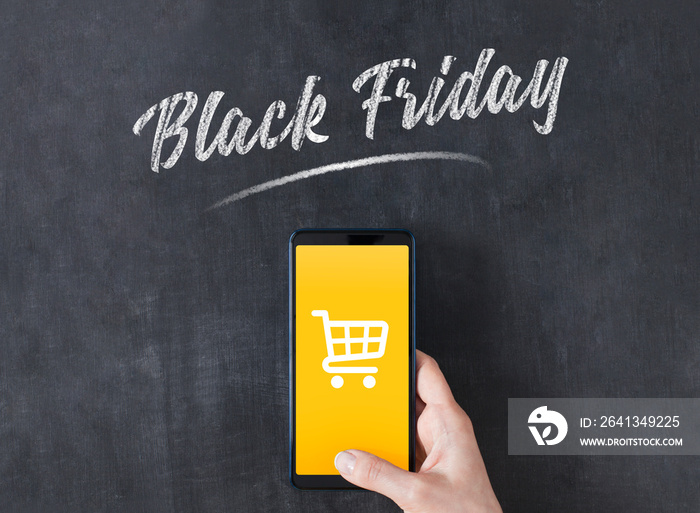 Black friday advertisement on blackboard. Woman shopping with smart phone app.