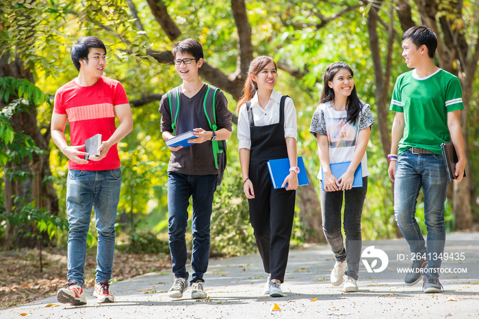 亚洲大学生在路上穿过公园