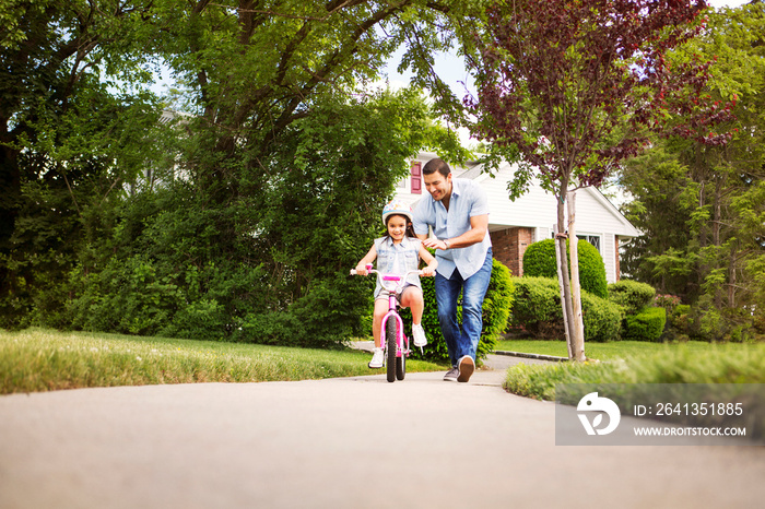 Girl (8-9) cycling in suburbs