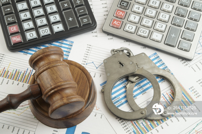 Financial fraud concept, judge gavel, calculators and handcuffs on financial documents