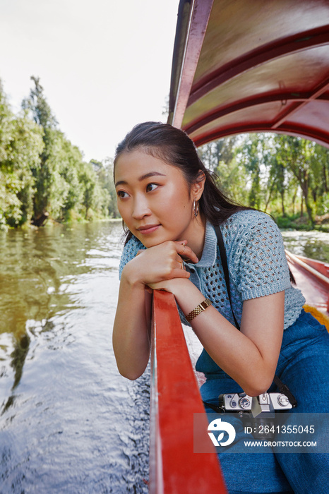 Thoughtful young woman sitting in trajinera boat