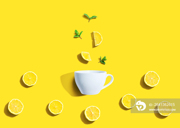 Fresh yellow lemons with tea cup overhead view