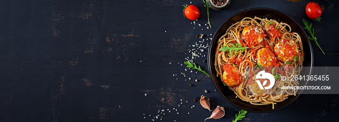 Italian pasta. Spaghetti with meatballs and parmesan cheese in black plate on dark rustic wood backg