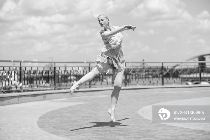 Ballerina in city. Ballet dancer dancing outdoor. Concept of freedom and sport body