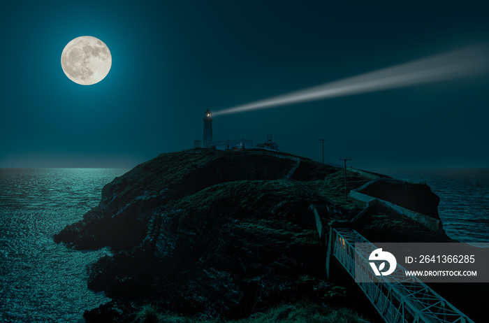 A full moon night at the South Stack lighthouse on the Irish Sea. The moonlight is reflected by the 