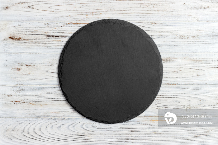 Round slate stand board a wooden background. space for text