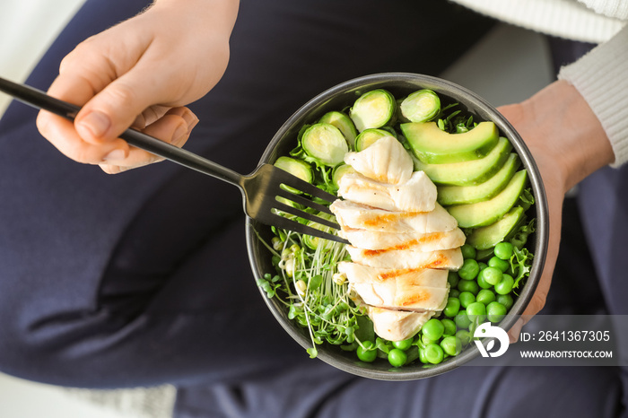 Woman eating tasty salad with fresh vegetables and chicken, closeup