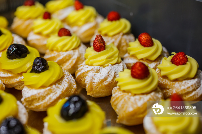 Zeppole fritte napoletane guarnite con crema pasticciera, fragoline e ciliegie