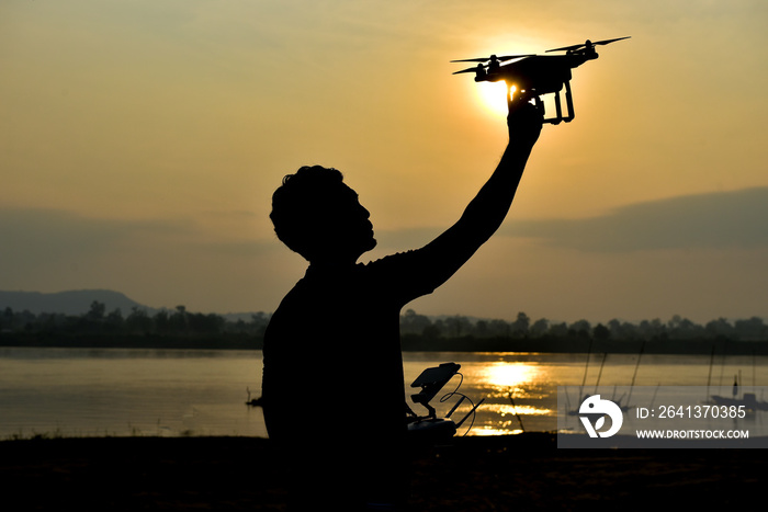 Men during control joy stick drones to take pictures of the sunset.