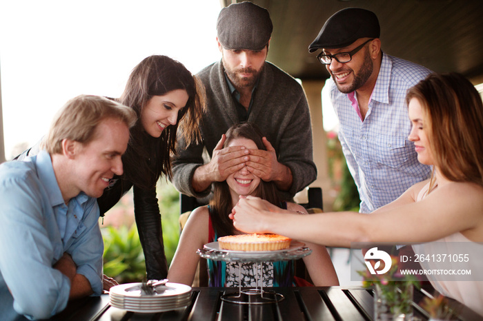 People celebrating friends birthday surprise birthday cake