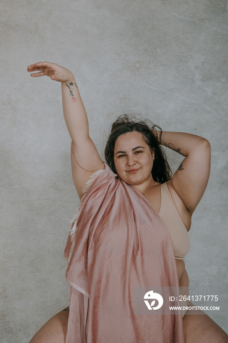 plus size metis woman smiling at camera reaching up