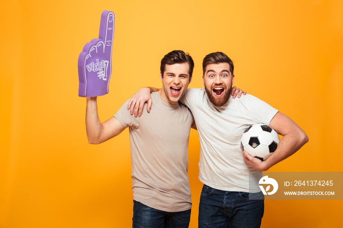 两个快乐的年轻人拿着足球的画像