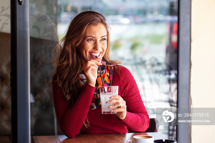 Woman in red sitting in cafe with lemonade and relax