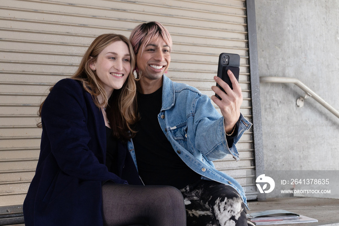 Lgbtqia friends laughing on their phone.