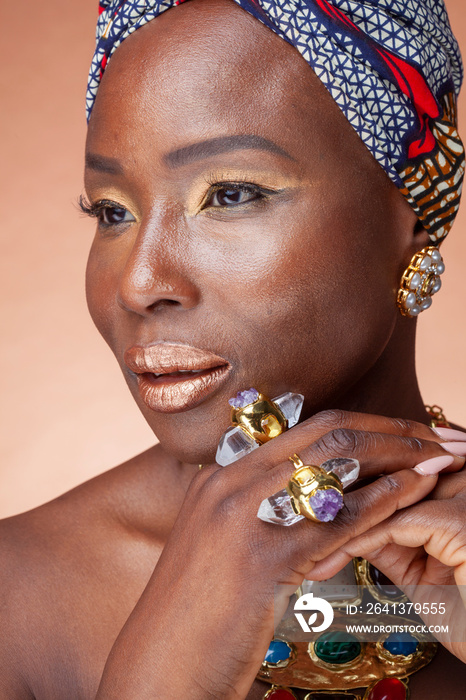 Portrait of woman with golden make-up, headscarf and jewelry