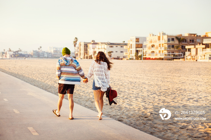 Young couple holding hands city in background