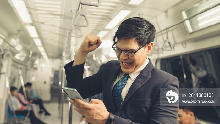 Businessman using mobile phone on public train . Urban city lifestyle commuting concept .