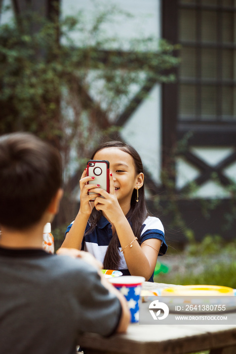 Friends taking pictures at table