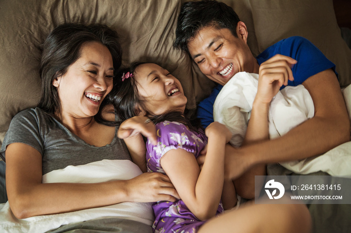 Smiling family relaxing on bed