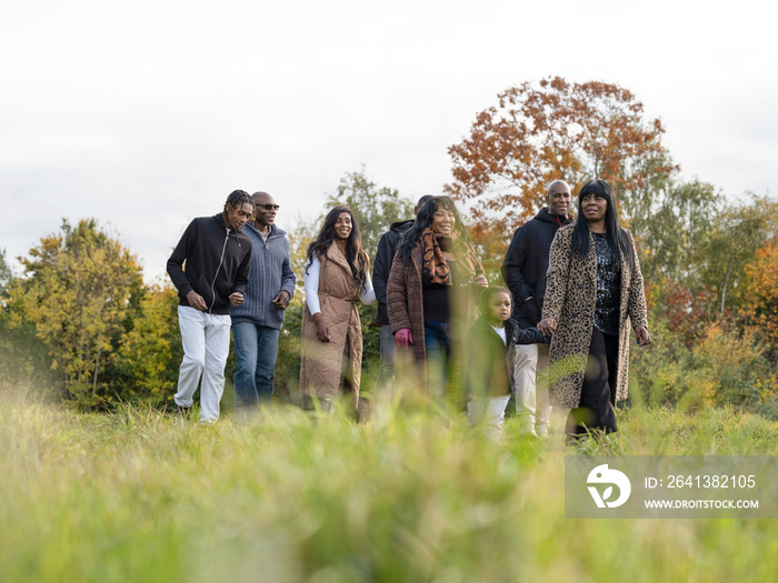 Multi-generational family walking in meadow