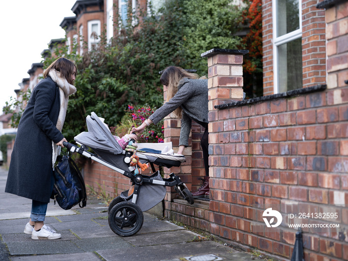 Women bringing baby stroller over step�