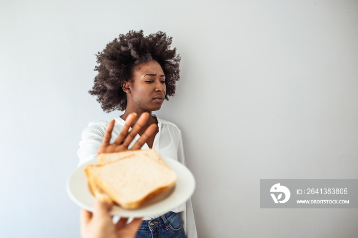 Young woman on gluten free diet is saying no thanks to toast. A woman on a gluten free diet is sayin