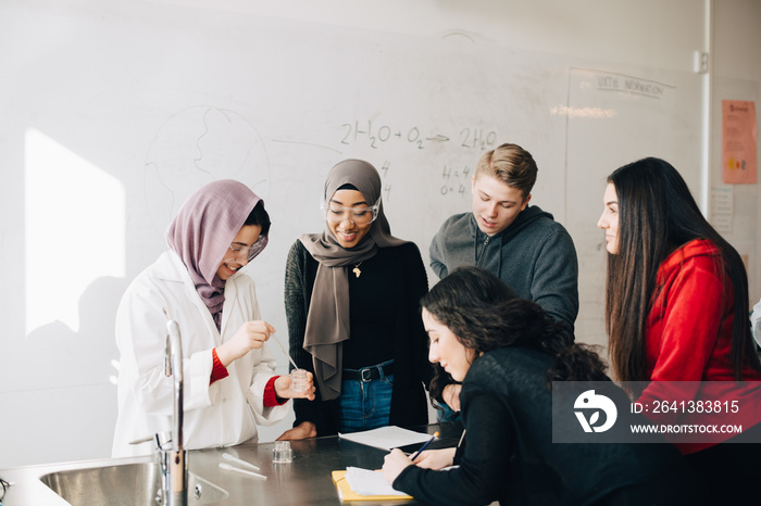 Multi-ethnic curious students learning chemistry in university