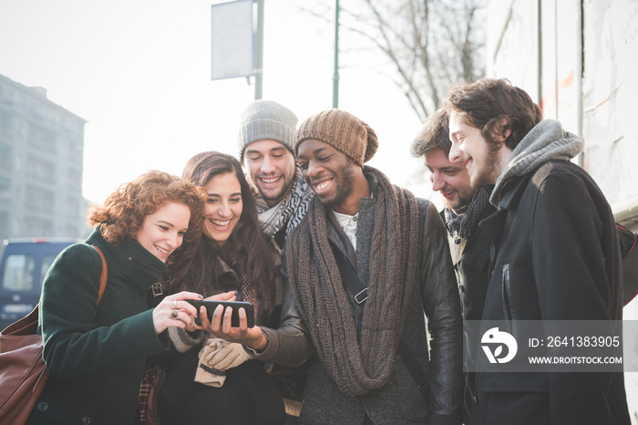 Six young adult friends reading smartphone texts