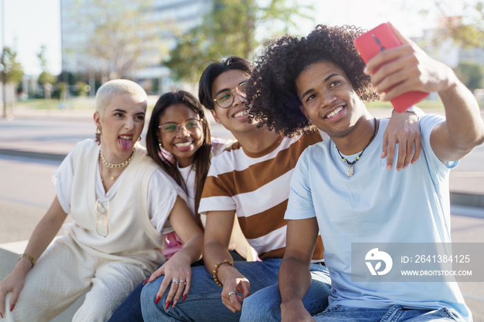 Black Young man with Afro Hairstyle takes selfie with group of diverse gen z teenager friends