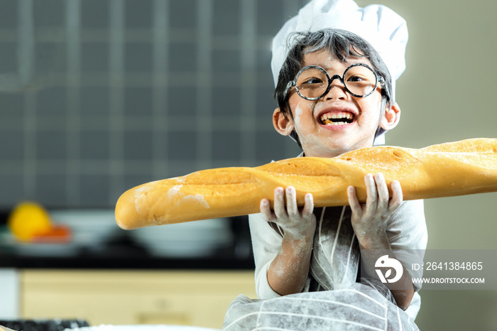 生活方式家庭。微笑的厨师亚洲小男孩烤面包，晚餐做面包。人们是孩子