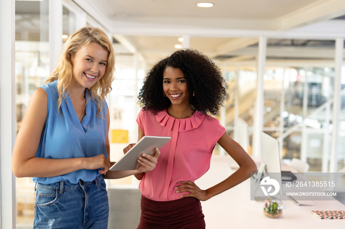 Female executives discussing over digital tablet in office