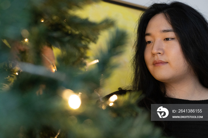 Asian American trans woman decorating for the holidays.