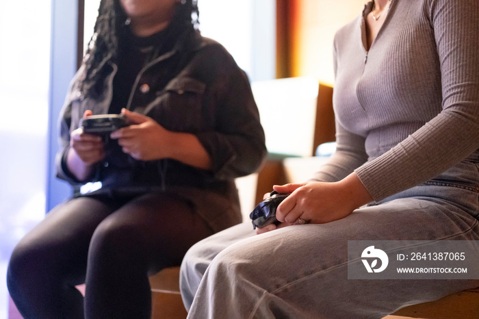 Female friends playing in video games at pub