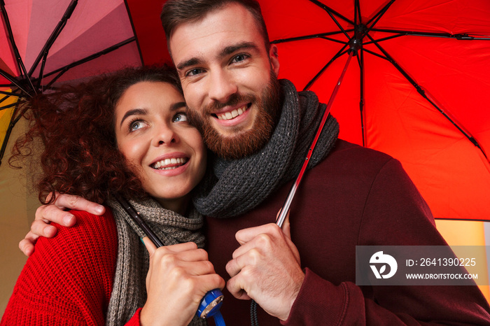 带伞的幸福年轻情侣。