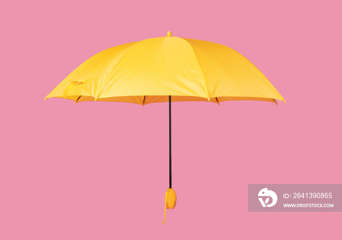 打开的黄色雨伞被隔离在粉红色背景上