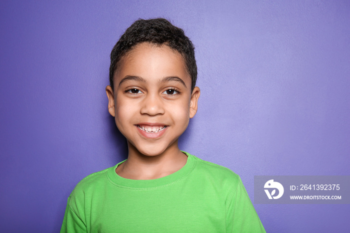 Portrait of cute little boy on color background