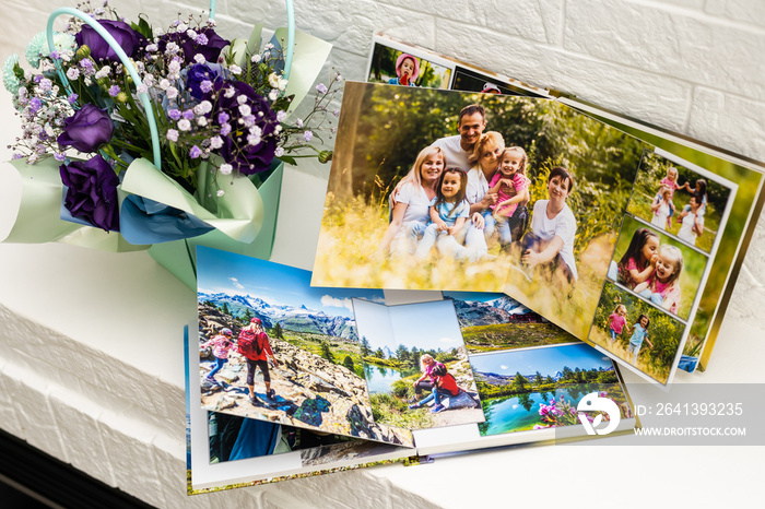 在白色桌子上打开家庭照片拍摄的相册。保存生命中的重要时刻