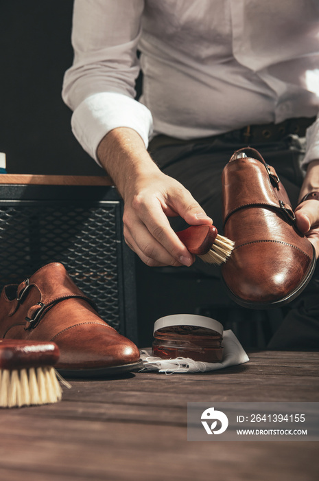 Man applies shoe polish with a small brush