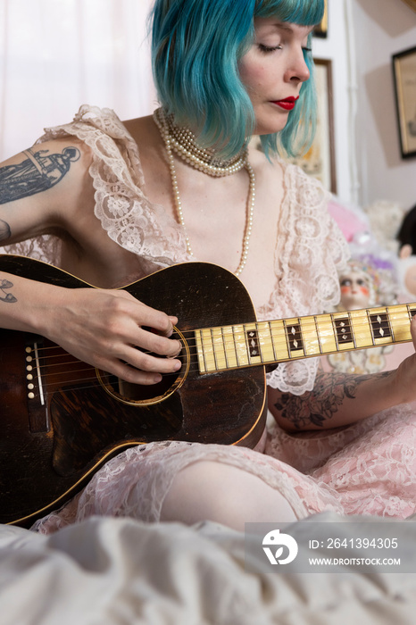 蓝头发女人在家弹古董吉他