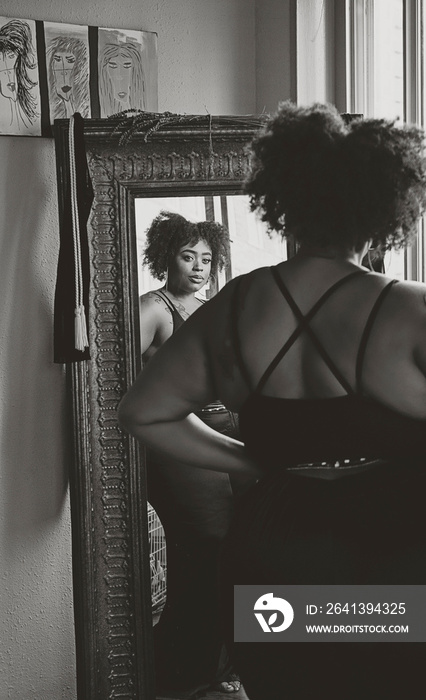 Black woman admiring herself in the mirror